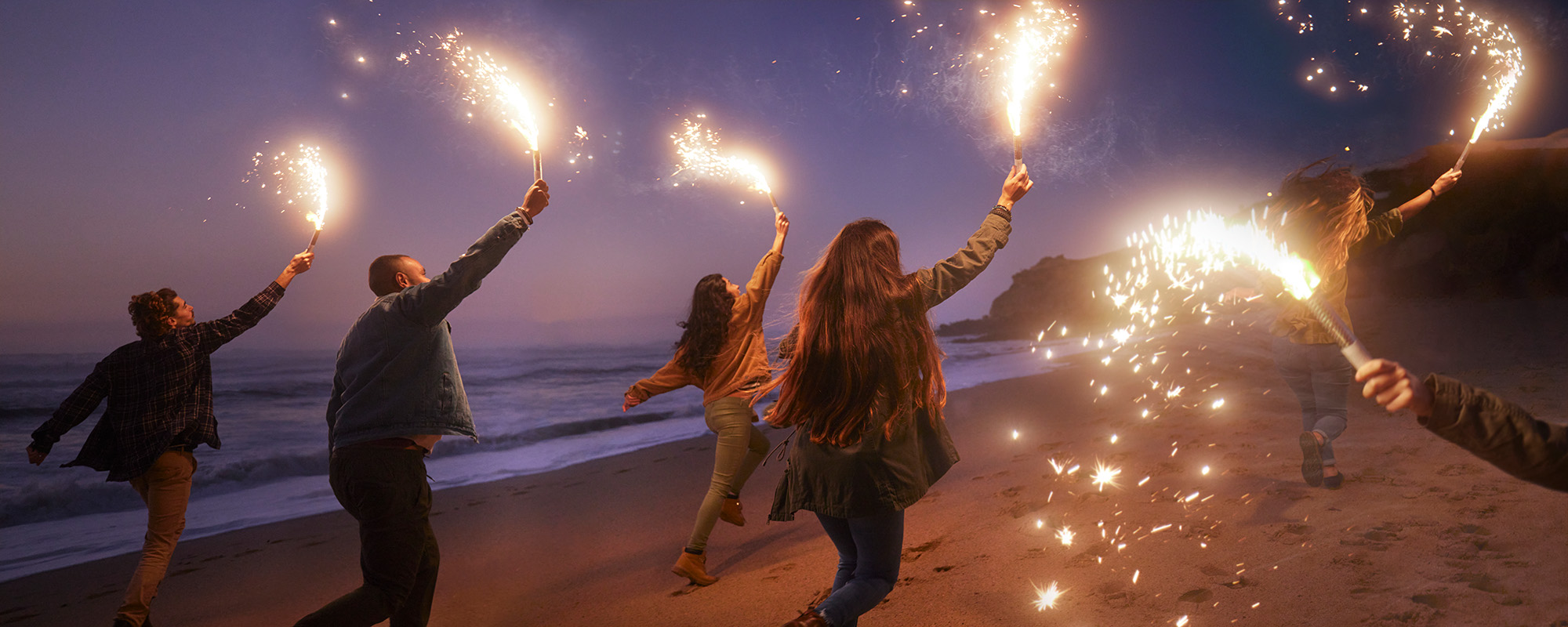 Foto Leute mit Wunderkerzen am Strand